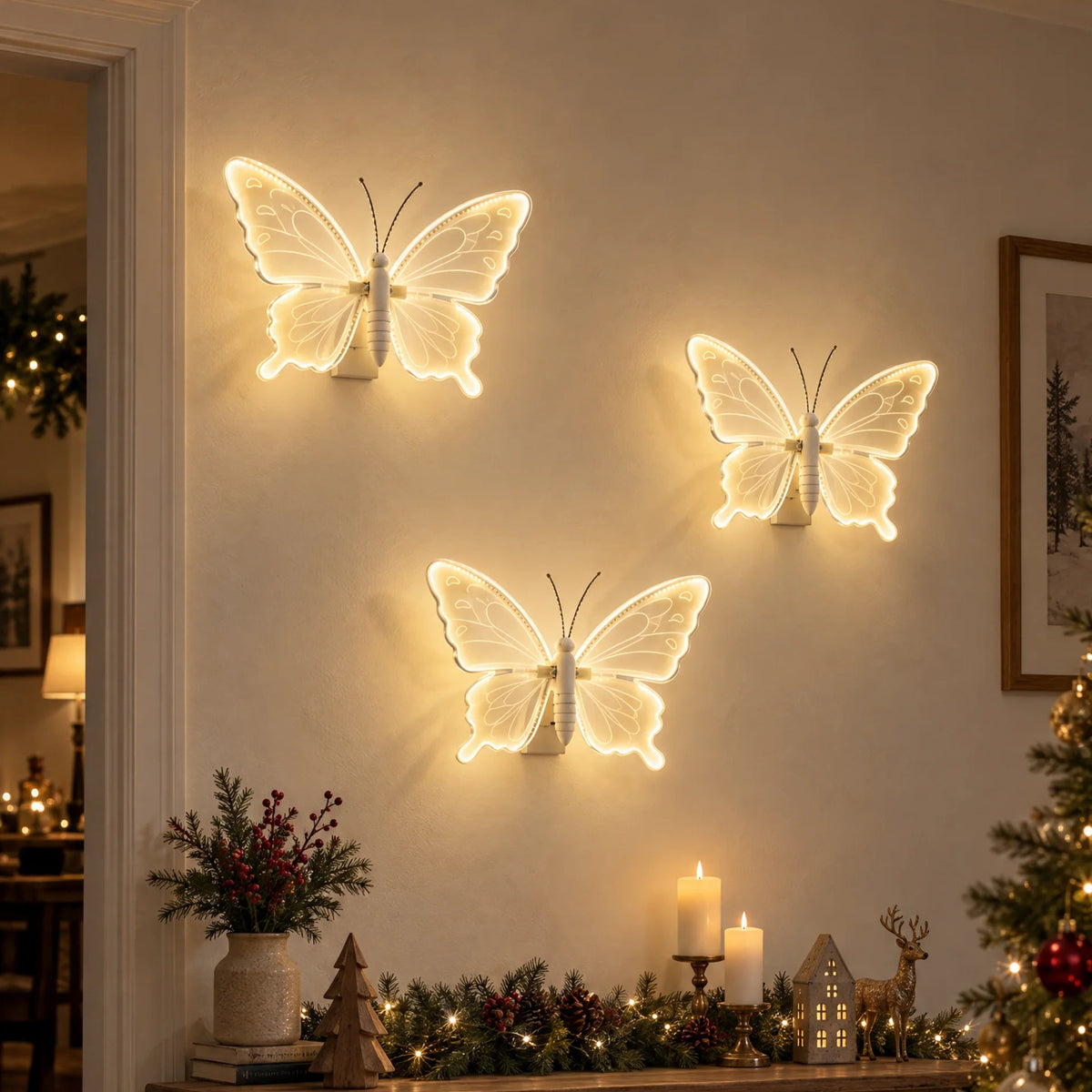 Three glowing butterfly wall lights mounted on a wall in a cozy holiday living room, with a wooden console table, candles, greenery, and a decorated Christmas tree nearby.